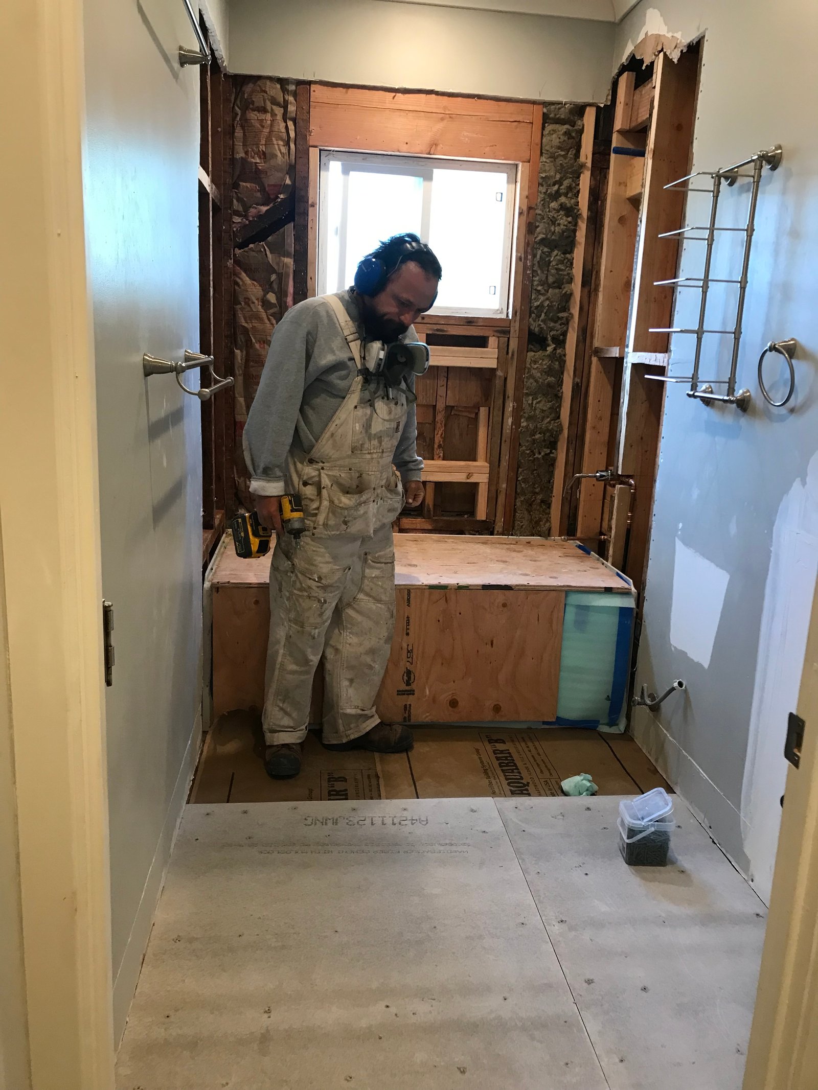 Installer setting mosaic tile inside a shower niche