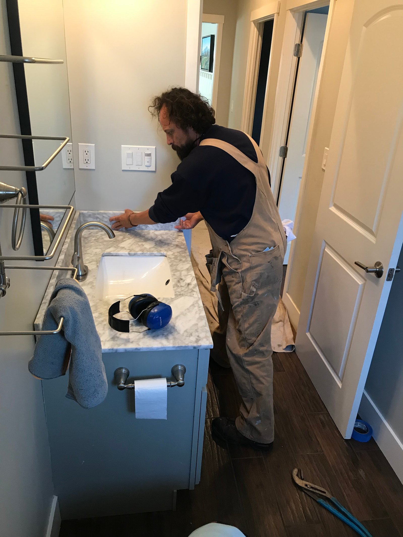Installer adjusting a new toilet seat during bathroom remodel